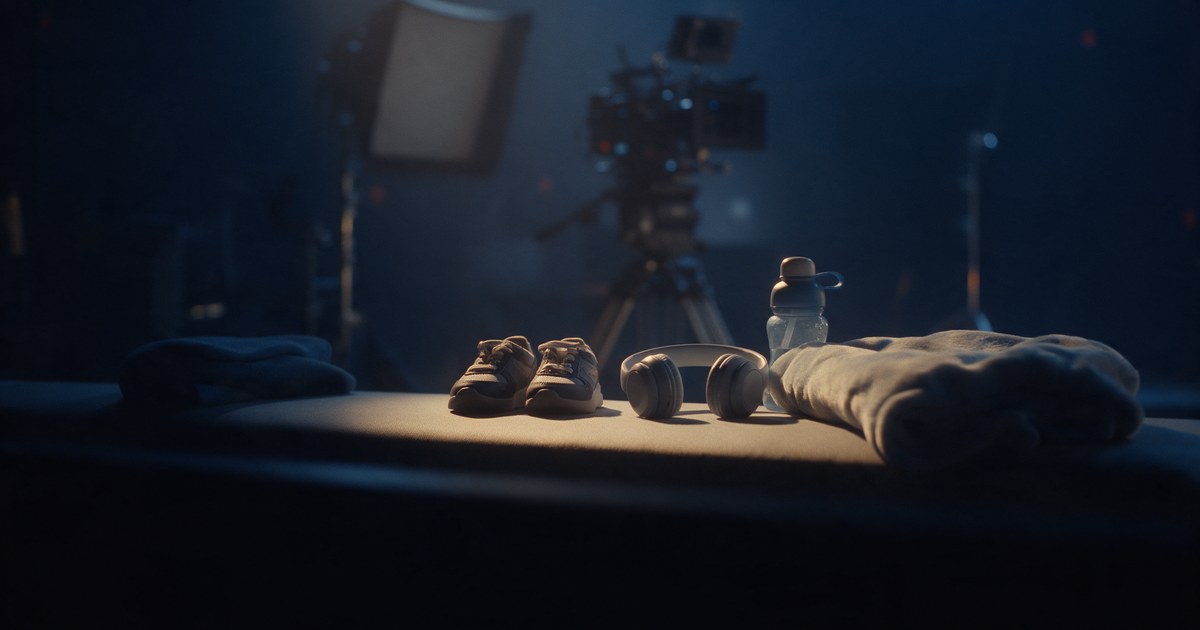Small sneakers, child-size headphones and a water bottle on a bench in a quiet corner of a film set